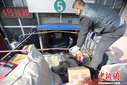 資料圖：工作人員正在給快遞包裹裝車。張?jiān)啤z